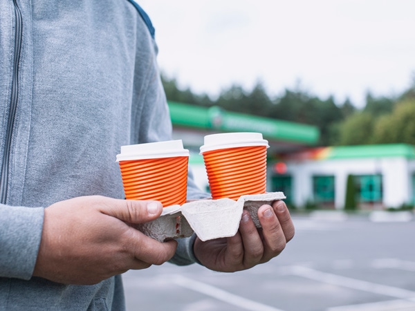 a person holding two cups of Servo Coffee