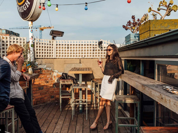 a woman holding a drink atop Marquis of Lorne, Fitzroy