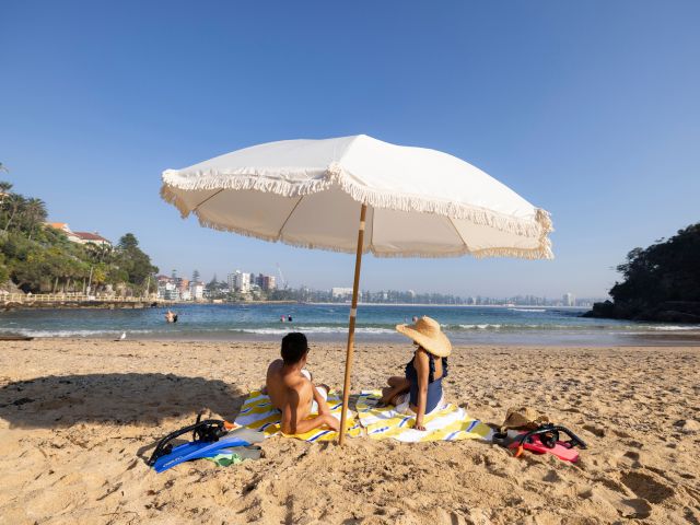 relaxing under a beach umbrella at Shelly Beach, Manly