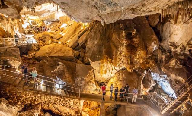 A group of people tour the intricate Jenolan Caves