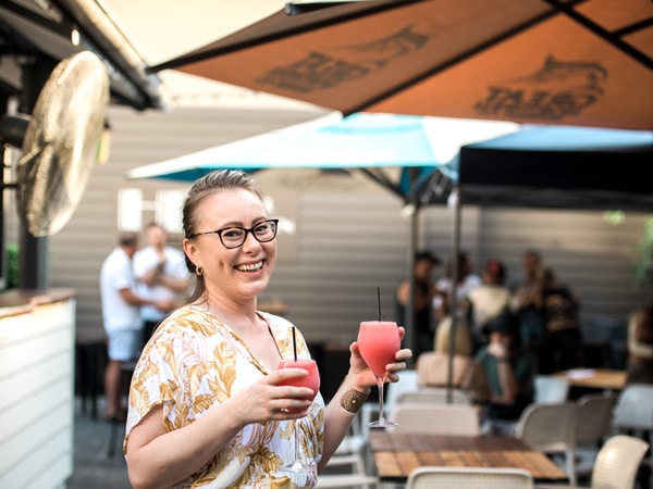 a woman holding drinks at Hotel Darwin