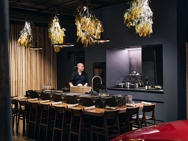 Omotenashi is a 12-seat counter-style kaiseki restaurant located in a Lexus showroom with cars alongside the kitchen