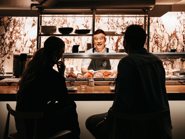 a couple sitting in the bar counter at Saké Restaurant and Bar