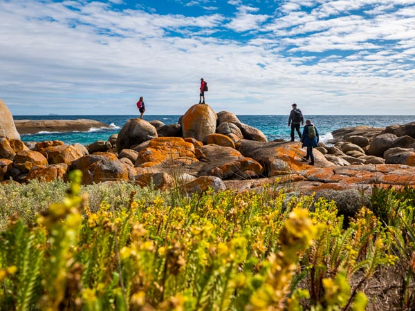 Walkers Hop Over Granite Boulders on Flinders Island