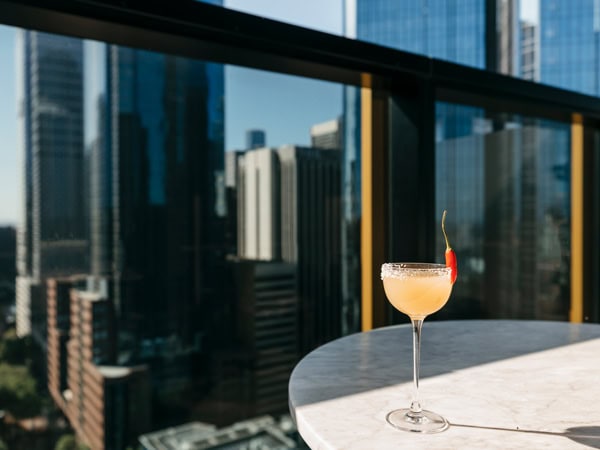a glass of cocktail on the table at Q rooftop bar, Melbourne