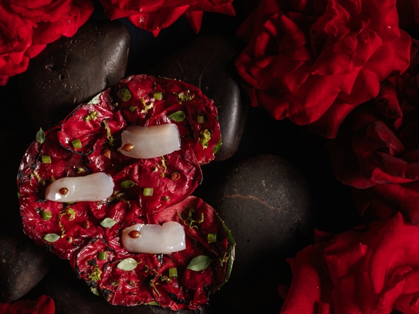 Scallop, grilled roses, native basil, and wasabi on a bed of roses.