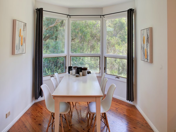 the dining table facing a window at Banksia Cottage
