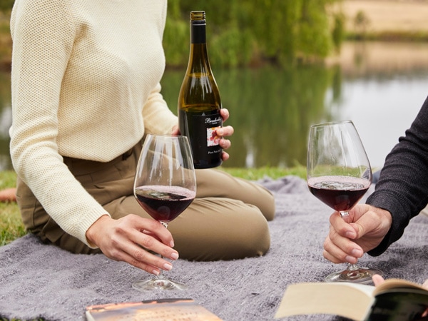 a couple drinking wine by the lake at Bendooley Estate