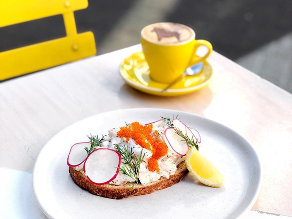 Coffee and breakfast dish on a table at Fika in Manly