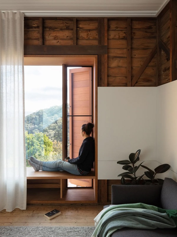 a woman sitting by the window at the Little Black Cabin, Blackheath