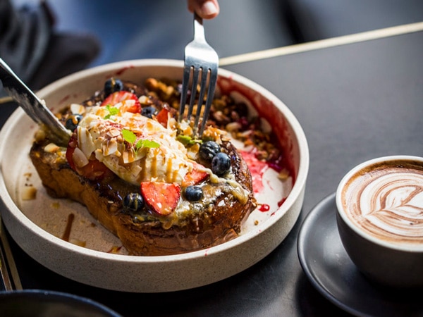 a close-up of food on the plate with coffee on the table at Sticky Fingers, Surry Hills