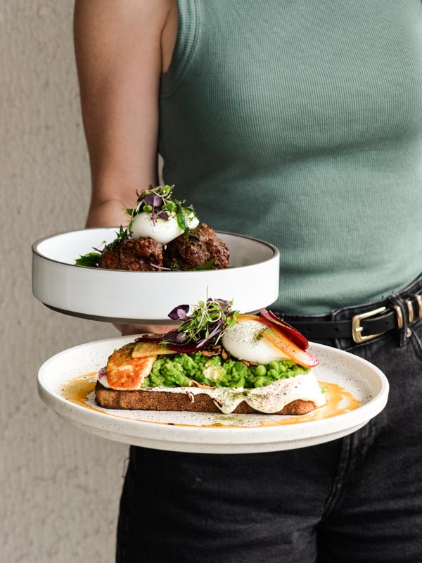 Waitress at Tinker holds two breakfast plates of food