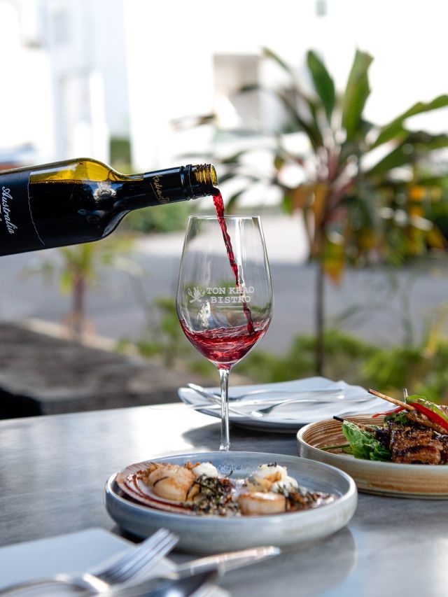 pouring wine into a glass at Ton Khao Bistro, Mooloolaba