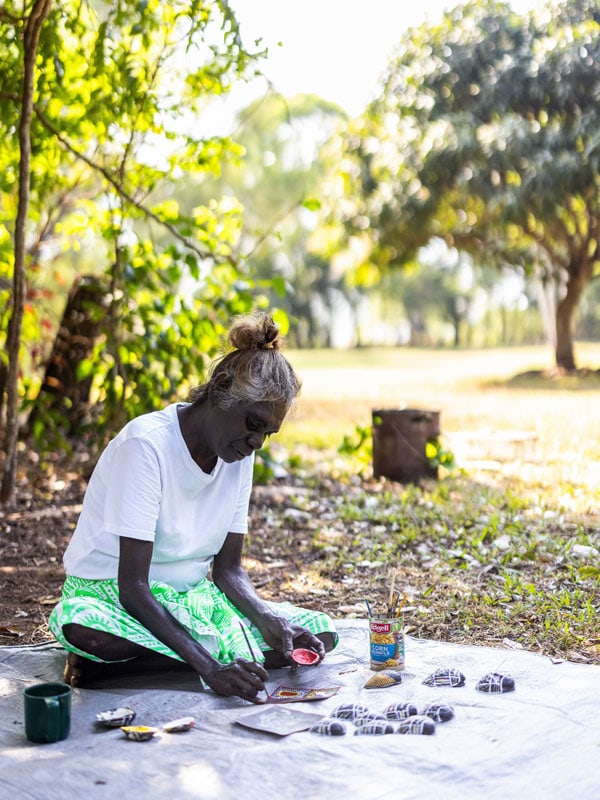 a Tiwi artist painting outdoors