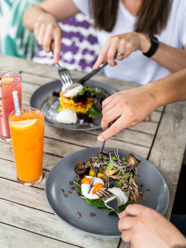 a close-up of two people consuming their meals at Anything Grows, Orange