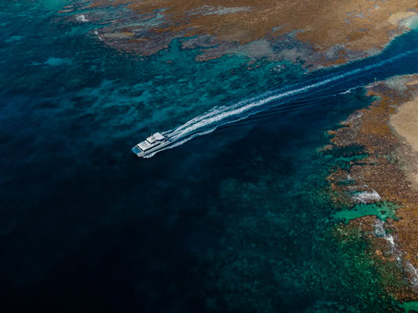 an aerial view of a ship sailing across the Great Barrier Reef