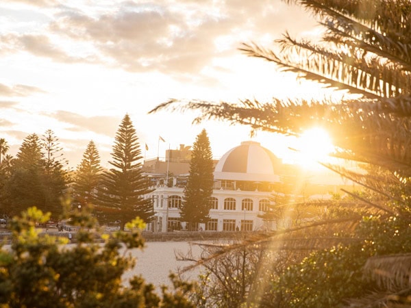 Coogee Bay Pavilion features in the background at sunset
