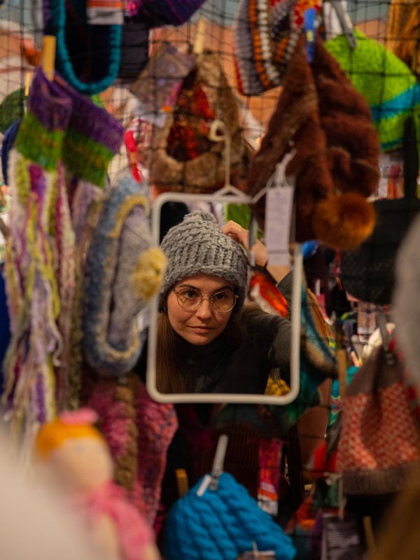 Woman tries on a beanie at the Beanie Festival in Alice Springs