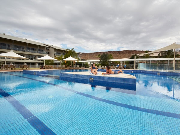 a couple relaxing in the pool at Crowne Plaza Alice Springs Lasseters