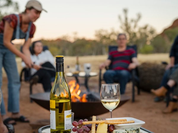 a wine and cheese platter with bonfire in the background at Squeaky Windmill, Alice Springs