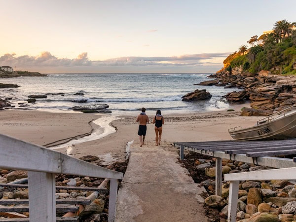 A couple walking to the water at Gordon's Bay for a swim