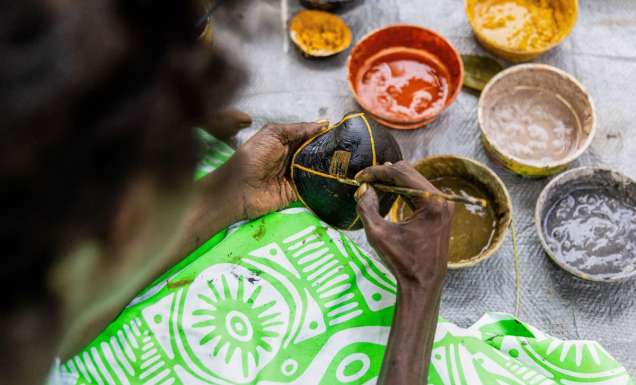 a close-up of a Tiwi artist painting