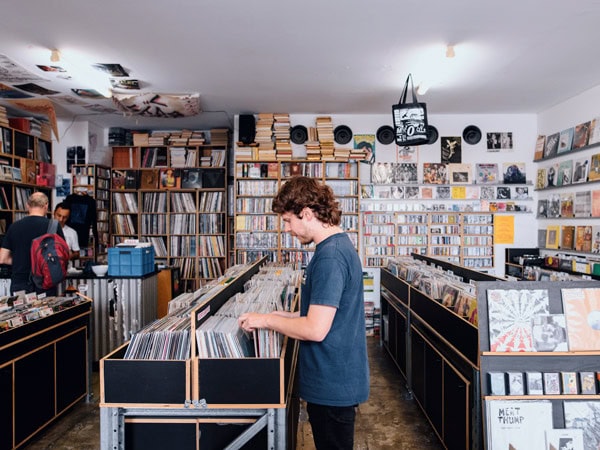a person browsing through vinyl records at Repressed Records