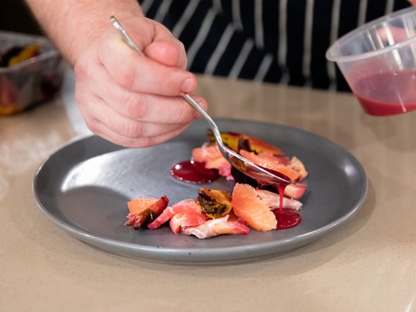 pouring sauce over a dish at Saltbush, Alice Springs