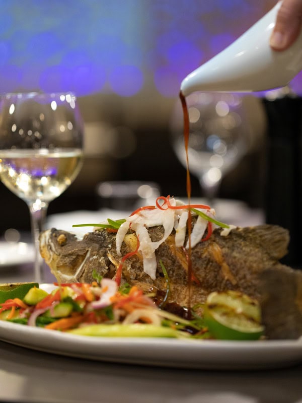 pouring sauce over fish at Saltbush, Alice Springs