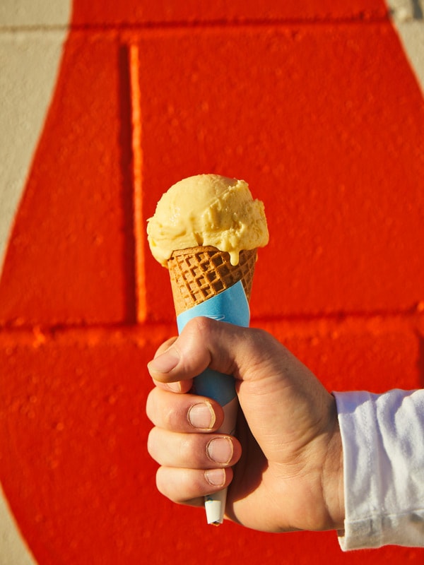 a hand holding a cone of gelato from Spilt Milk Bar