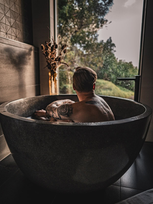 a man sitting in a tub at Still at Freycinet, Coles Bay, Tas