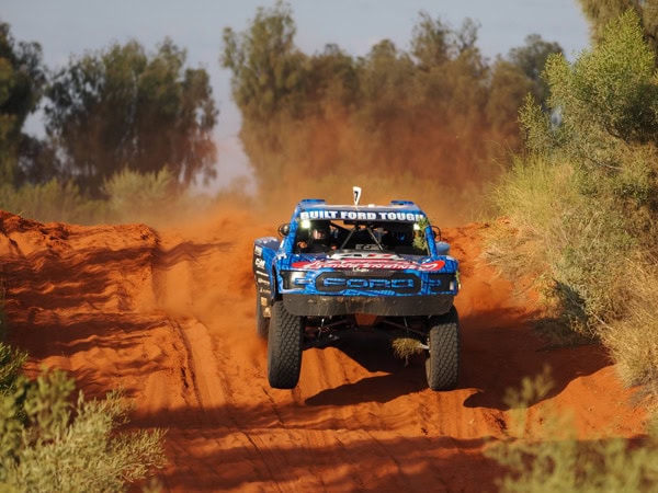 a vehicle driving through the dusty road during the Tatts Finke Desert Race