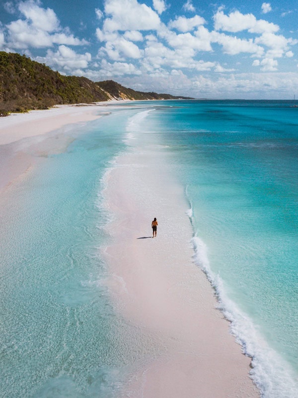 a man walking along the west coast of K'gari