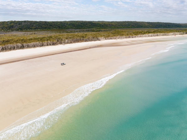 an aerial view of a 4WD driving along the Flinders Beach
