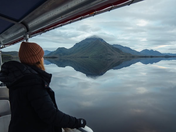 a woman looking out the mountain views from On Board's expedition vessel