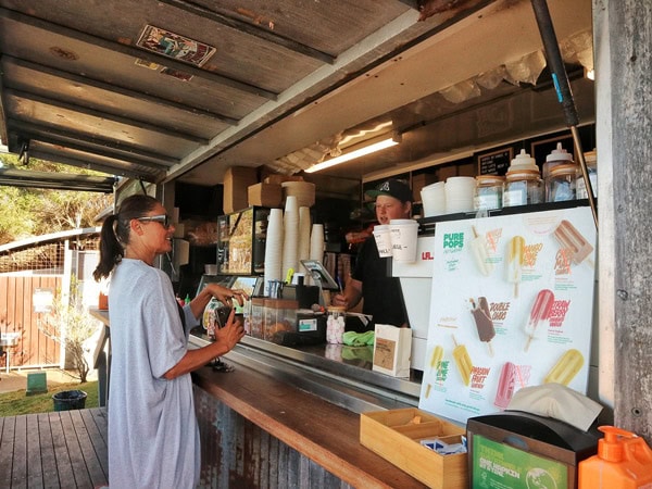 a woman ordering a drink at Bar Beach Kiosk, Merimbula