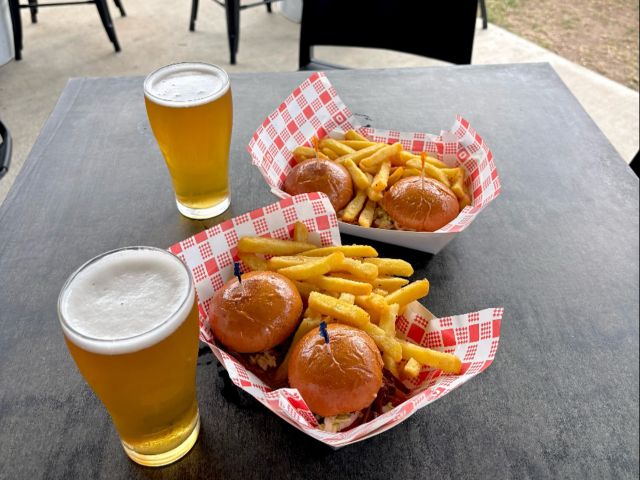 two glasses of cold beer alongside burger and fries at Mogul Beer, Coffs Harbour
