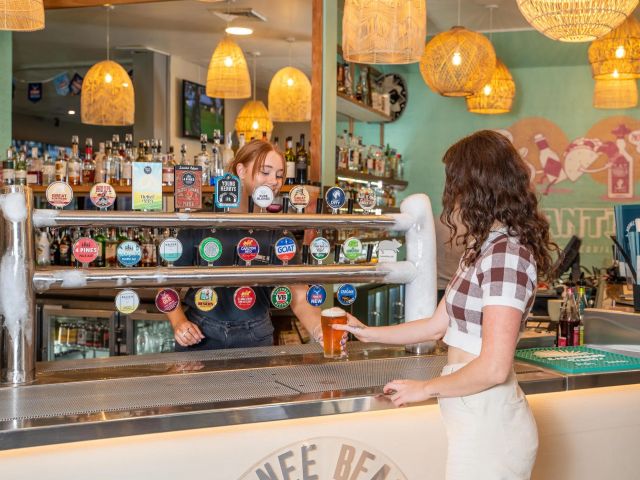 a woman ordering a tap beer at Moonee Beach Hotel, Coffs Harbour
