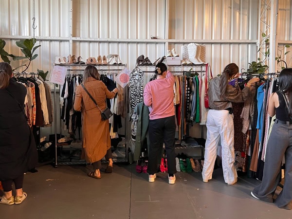 people browsing through the clothes on display at Love Me Again