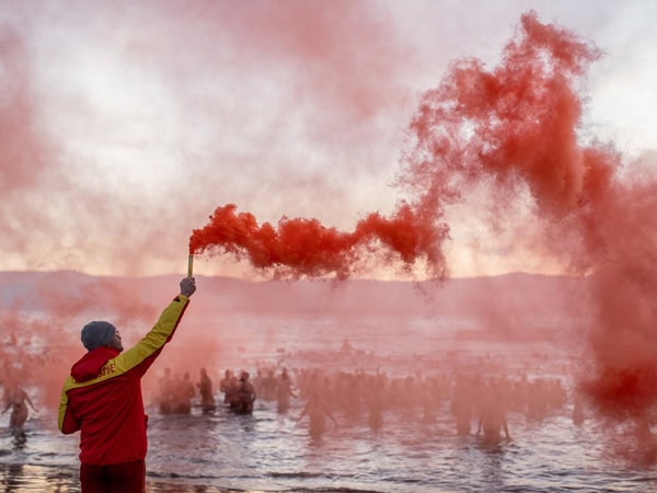releasing red smoke at Dark Mofo's infamous Nude Solstice Swim 