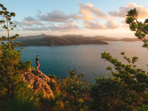 a man gazing at the scenic views atop Passage Peak on Hamilton Island, Qld