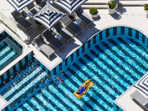 a woman floating at the infinity pool at QT Hotels Gold Coast