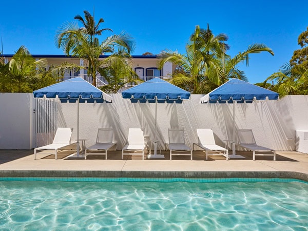 the pool with sunloungers at The Sails Motel & Pool Club