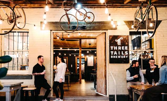 Patrons enjoying a drink at Three Tails Brewery