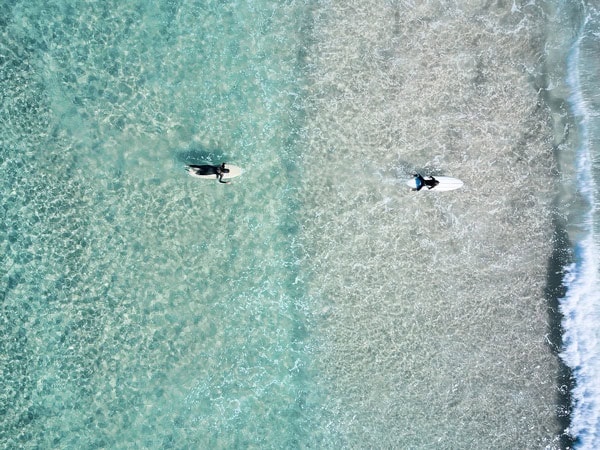 an aerial view of surfers at The Pass, Byron Bay