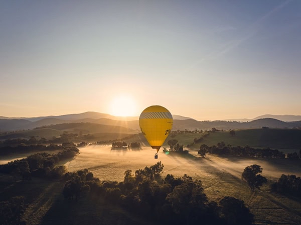 a hot air balloon above Yarra Valley at sunrise