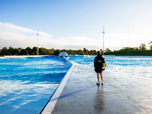 a lifeguard walking on the poolside path at URBNSURF Sydney
