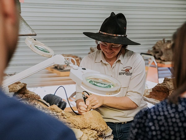 Palaeontologist shows their work to a tour group at Australian Age Of Dinosaurs winton guide