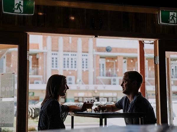 couple drinking beer inside Australian Hotel in winton