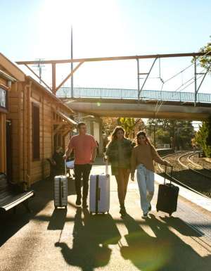 Young people with luggage catching a train at Katoombatrain station.